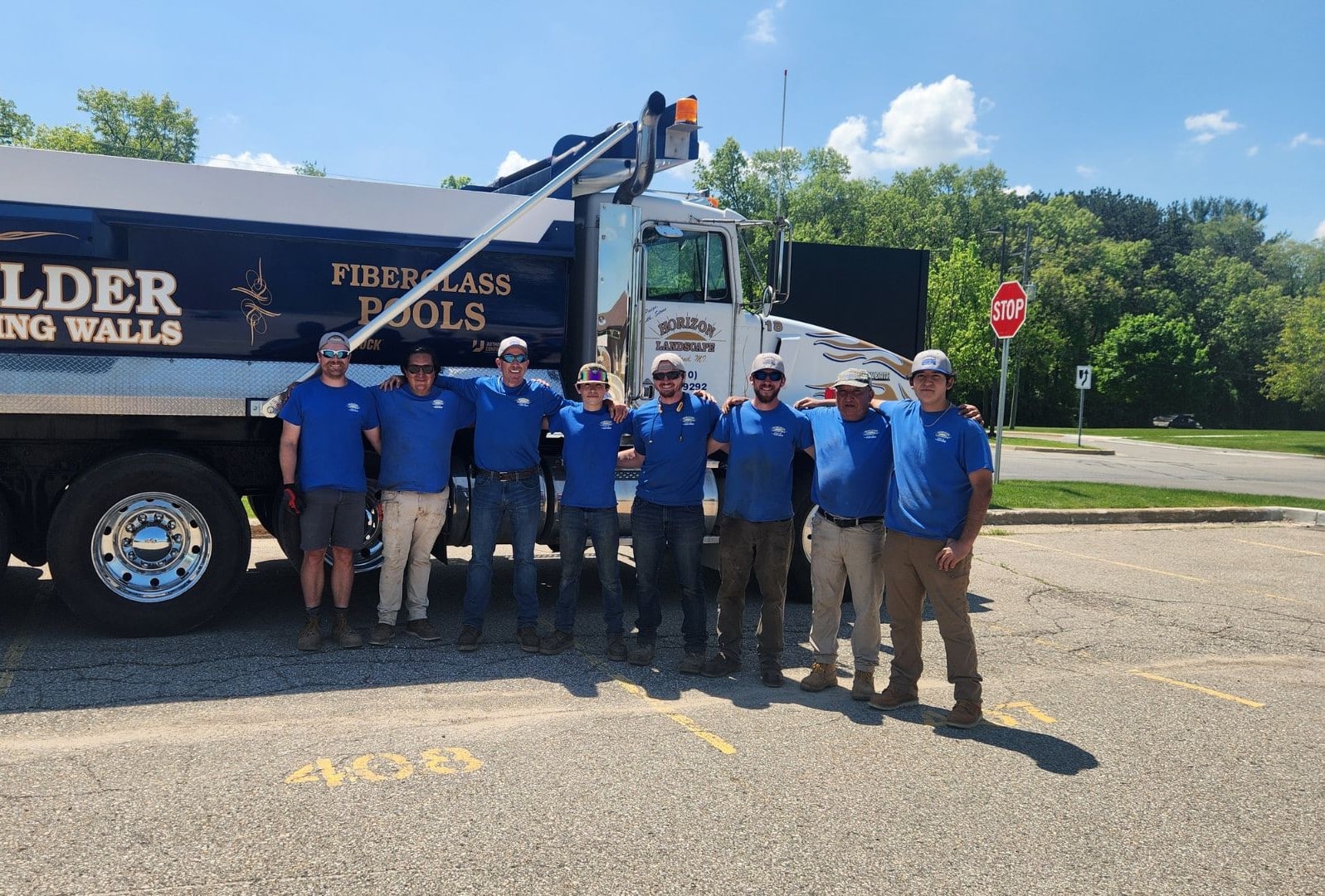photo of landscape techs outside standing in front of a blue trucl