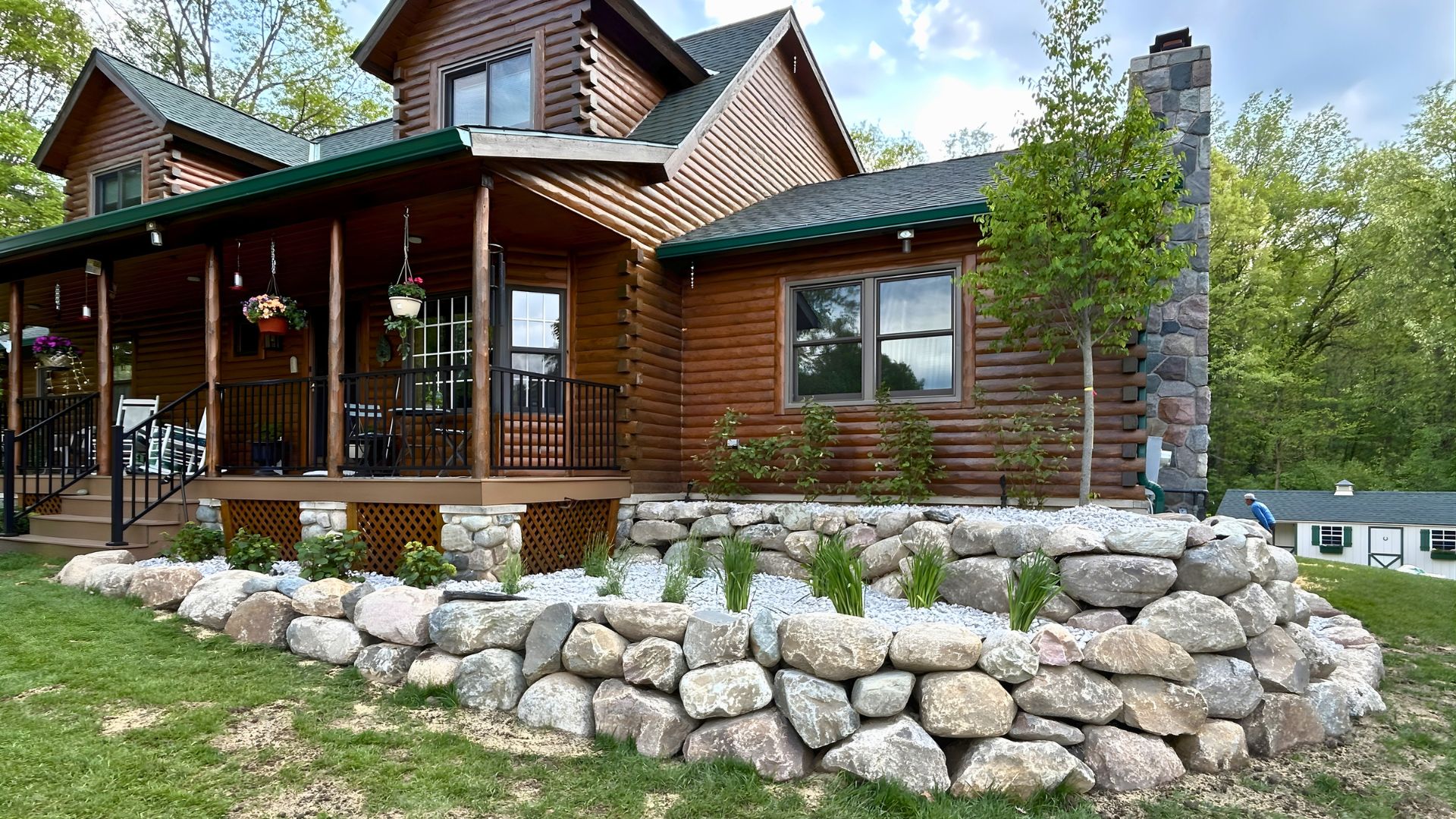brown house with a boulder retaining wall