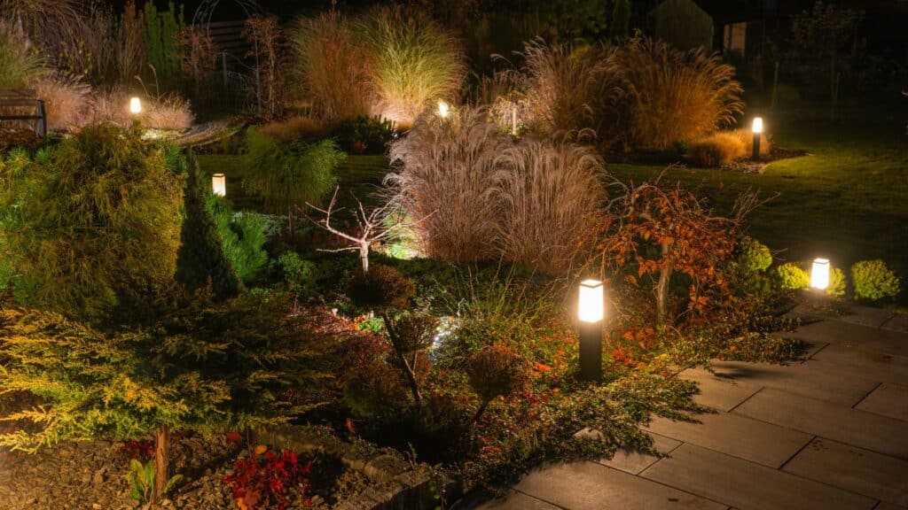 dim lighting around a garden bed of bushes and grasses to illuminate